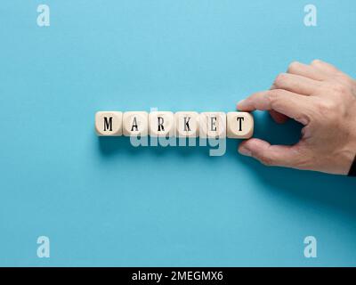 Konzept des Geschäftsmarkts. Männliche Hand arrangiert die Holzwürfel mit dem Wort Markt. Stockfoto