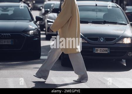 Mailand, Italien - 25. Februar 2022: Seitenansicht einer anonymen Frau in lässiger Kleidung beim Gehen. Stockfoto