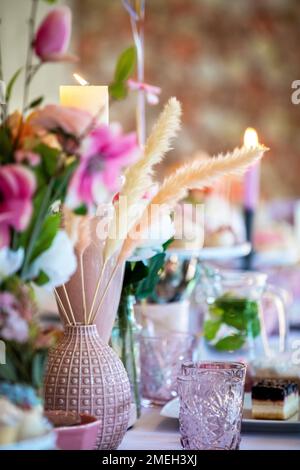 Tischdecken auf einer luxuriösen Hochzeit oder Party, Babydusche, Geburtstag und wunderschöne Blumen, Kuchen, Kerzen Dekoration auf dem Tisch. Stockfoto