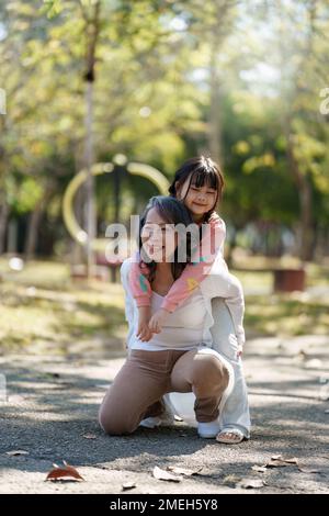 Asiatische Großmutter und Enkelin umarmen sich gemeinsam im Park. Hobbys und Freizeit, Lifestyle, Familienleben, Happiness Moment Konzept Stockfoto