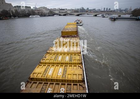 Die Fracht wird an einem Winternachmittag in London, England, Großbritannien, mit einem Schleppboot entlang der Themse manövriert Stockfoto