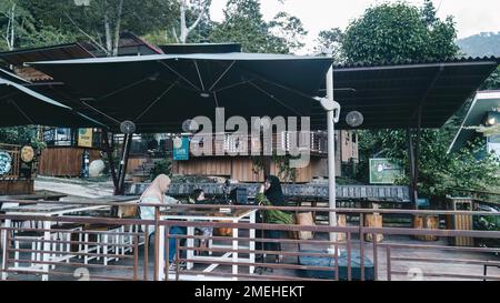 Perak, Malaysia - 19. Okt. 2022 Familie sitzt auf der hölzernen Terrasse im Kuak Hill Resort in Lenggong. Stockfoto