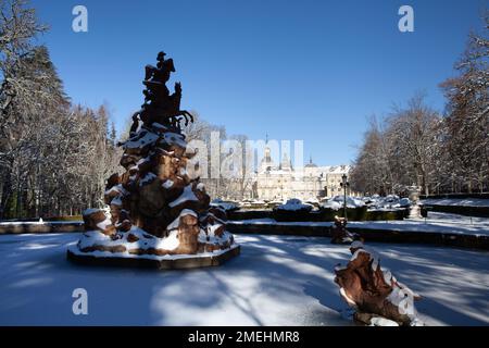 San Ildefonso, Spanien - 4. Januar 2022: Berühmtheitsbrunnen in den Gärten des Königspalastes von La Granja de San Ildefonso, bedeckt mit Schnee an einem sonnigen Tag Stockfoto