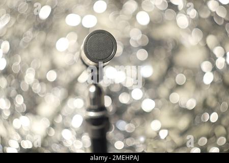 Podcasting-Konzept, klassisches Aufnahmemikrofon auf Bokeh-Bällen im Hintergrund, Nahaufnahme mit selektivem Fokus Stockfoto