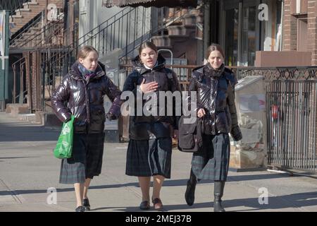 3 orthodoxe jüdische Schulmädchen gehen zusammen nach Hause und tragen den gleichen karierten Rock, die Uniform ihrer Schule. In Brooklyn, New York, 2023 Stockfoto