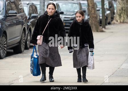 2 orthodoxe jüdische Schulmädchen gehen zusammen nach Hause und tragen dieselben Röcke, wahrscheinlich die Uniform ihrer Schule. In Brooklyn, New York, 2023 Stockfoto