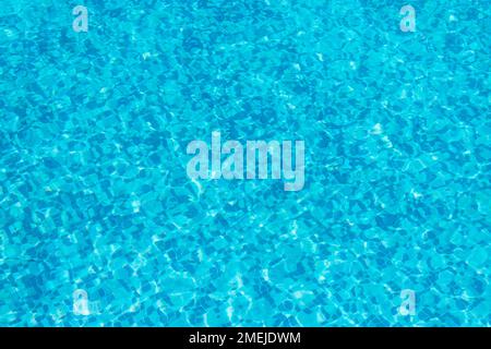 Hintergrund und Wellenmuster von klarem Wasser im blauen Swimmingpool. Stockfoto