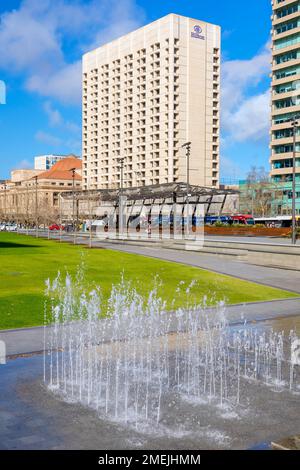 Adelaide City, Südaustralien - 19. August 2019: Victoria Square Fountain an einem Tag mit Hilton Hotel im Hintergrund an einem hellen Tag Stockfoto