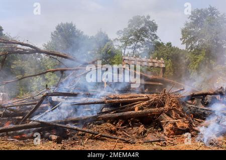 Während des Baus des Hauses wurde der entwurzelte Wald verbrannt, um das Haus zu bauen und so den Bau zu unterstützen Stockfoto