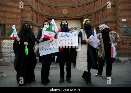 Teheran, Teheran, Iran. 24. Januar 2023. Iranische verschleierte Schülerinnen in schwarzen Chadoren, die iranische Flaggen tragen und auf einem Plakat mit der Aufschrift "Frankreich sei vorsichtig" stehen, versammeln sich, um zu protestieren, nachdem Charlie Hebdo am 24. Januar 2023 Karikaturen des iranischen Spitzenführers Ali Chamenei vor der französischen Botschaft in Teheran, Iran, veröffentlicht hat. Kredit: ZUMA Press, Inc./Alamy Live News Stockfoto