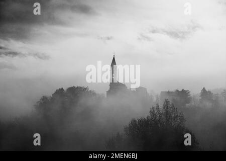 Die Kirche des Mysteriums, eine alte Kirche in den toskanisch-emilischen Apenninen, umhüllt von Nebel Stockfoto