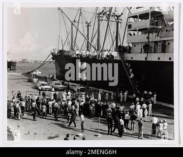 Die Menge erwartet die Ankunft der Flüchtlinge an Bord des SS African Pilot. Port Everglades, Florida Ungeduldige Nachrichtenmänner drängen sich herum und warten auf die Möglichkeit, Mitglieder der Besatzung des afrikanischen Piloten und die kubanischen Flüchtlinge, die an Bord dieses Schiffes in die USA gebracht werden, zu befragen. Stockfoto