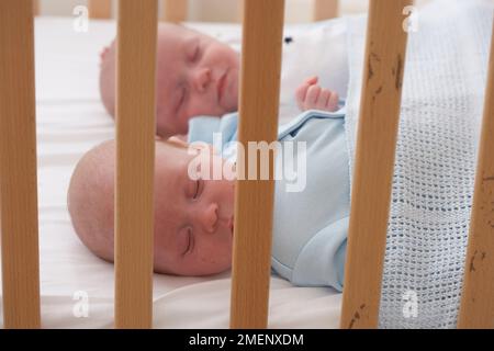 Zwillingsbaby und Mädchen schlafen zusammen im Kinderbett, Nahaufnahme, 5 Monate Stockfoto