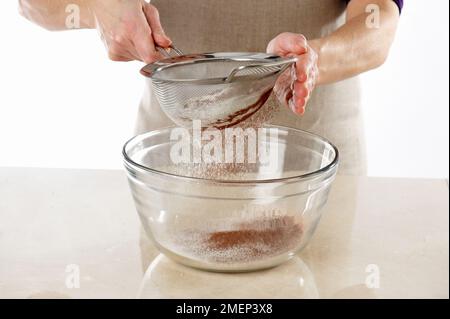 Schokoladenkuchen machen, Mehl zusammensieben, Kakaopulver, Backpulver Stockfoto