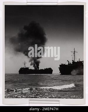 Ein Kriegsfotograf der Küstenwache fängt einen dramatischen Moment ein, als zwei LSTs sich Leyte Island während der Befreiung der Philippinen nähern. Ein LST wird von japanischem 37-mm-Feuer getroffen, während ein anderer von der Küstenwache bemannter LST den Angriff nur knapp vermeidet. Die feindlichen Geschützpositionen wurden von alliierter Infanterie schnell neutralisiert. Stockfoto