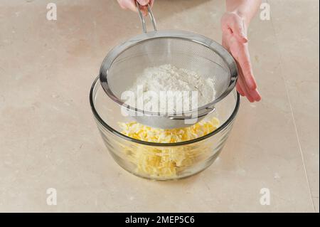 Ich mache Cinnamon Palmiers, sieben Mehl über geriebener Butter Stockfoto