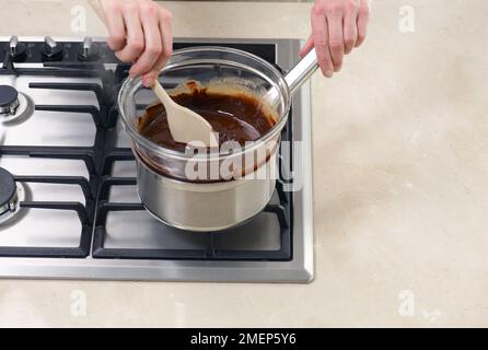 Brownies machen, Schokolade schmelzen und Butter in hitzebeständiger Schüssel über Pfanne Stockfoto