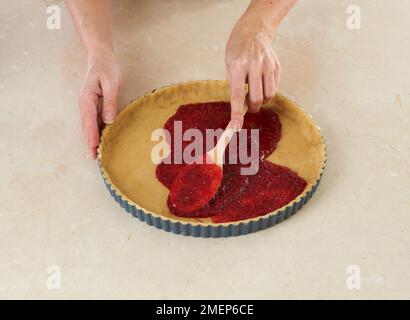 Herstellung traditioneller österreichischer Torte, Linzertorte, Himbeerfüllung auf Teigbasis Stockfoto