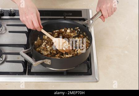 Schalotten, Knoblauch und Pilze in der Pfanne braten, um die Füllung für Boeuf en Croute zu machen Stockfoto