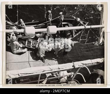 Die Küstenwache überführen ein an Blinddarmentzündung leidendes Mitglied der Navy von einem Handelsschiff zu einem Konvoi-Cutter der Küstenwache im mittleren Atlantik. Dr. Thomas S. Hersey, ein Chirurg des US-Gesundheitsdienstes, wird die Blinddarmtomie an Bord des sich bewegenden Schiffes durchführen. Stockfoto