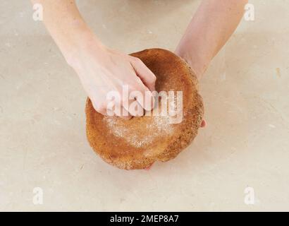 Soda-Brot, das Brot umdrehen und auf den Boden klopfen Stockfoto