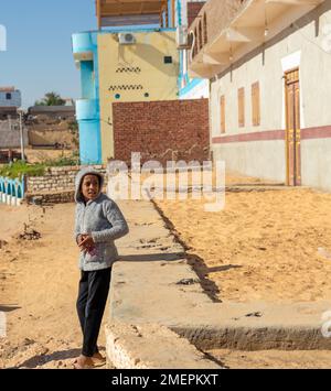 ASSUAN, ÄGYPTEN - 29. Dez. 2022. Armer Junge in einem ägyptischen, bunten Dorf in der Wüste. Jeden Tag in Afrika Stockfoto