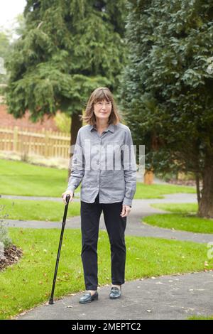 Eine Frau, die einen Gehstock benutzt Stockfoto