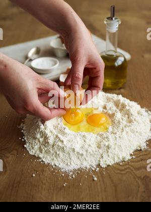 Das Mischen von Ei, Olivenöl und Mehl (Pasta Teig) Stockfoto