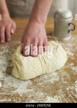 Kneten von Brotteig auf bemehlten Oberfläche Stockfoto