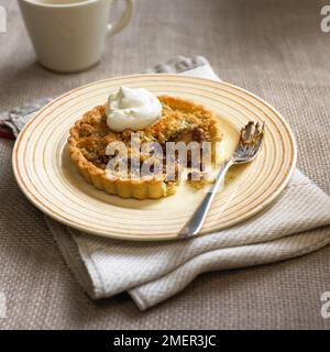 Banane und Schokolade verteilt tartlet bröckeln, serviert mit klacks Sahne Stockfoto