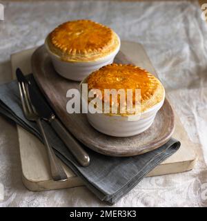 Zwei chicken pot Pies auf Serviertablett, mit Besteck Stockfoto