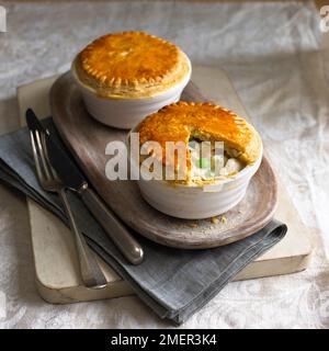 Zwei chicken pot Pies auf Serviertablett, mit Besteck Stockfoto