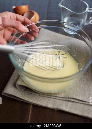 Eigelb mit etwas kaltem Wasser in der Schüssel mischen (Sauce Hollandaise kochen) Stockfoto