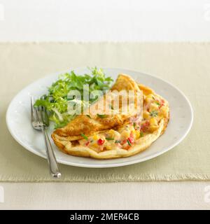 Käsesoufflé-Omelette mit Zuckermais, Paprika und Schnittlauch Stockfoto