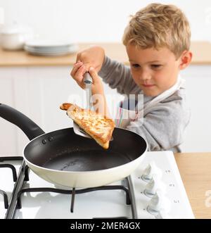 Ein Junge, der Eierbrot in einer Bratpfanne kocht, 4 Jahre Stockfoto