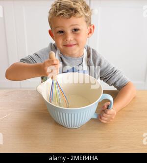 Junge, der Pfannkuchen-Mixgetränk macht, 4 Jahre Stockfoto