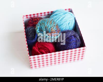 Bunte Wollkugeln im Karton Stockfoto