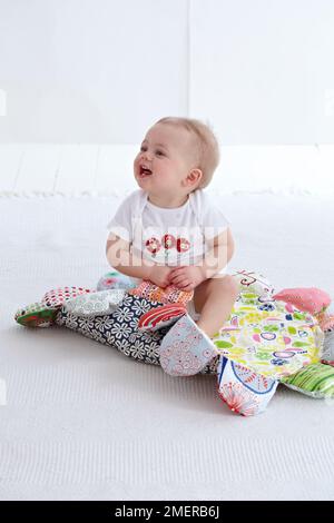 Kleiner Junge, 11 Monate, spielend auf der Spielmatte Stockfoto