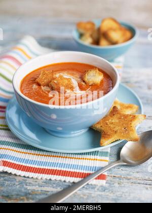 Tomatensuppe mit Sahne, serviert in einer Schüssel mit sternförmigem Toastbrot Stockfoto