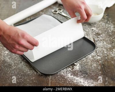 Lebkuchen, ein Blatt weißes Backpapier auf das Backblech legen Stockfoto