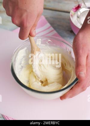 Mascarpone-, Vanille- und Puderzucker-Mischung mit Holzlöffel schlagen, um Obsttörtchen zu füllen Stockfoto
