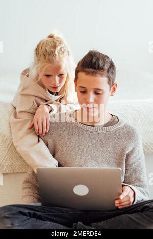 Teenager, Junge und Mädchen, die zusammen einen Laptop benutzen. Stockfoto