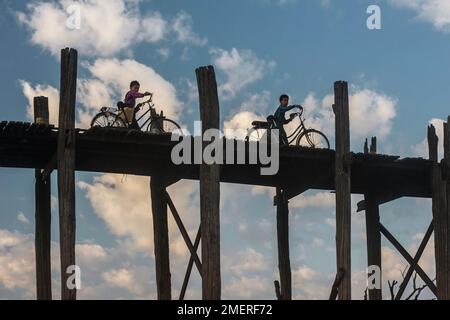 Myanmar, Mandalay, Amarapura, Kinder, die bei Sonnenaufgang ihre Fahrräder über die U-Beins-Brücke schieben Stockfoto