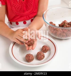 Ein Mädchen, das Fleischbällchen aus Hackfleisch macht Stockfoto