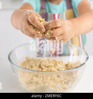 Mädchen, die Keksteig-Mischung aus Butter und Mehl macht Stockfoto