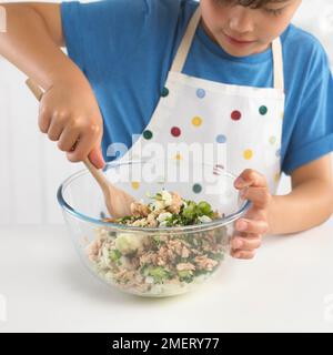 Fischkuchen machen, Junge Kartoffeln, Fisch und Frühlingszwiebeln mischen, 7 Jahre Stockfoto