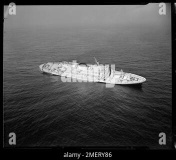 SS ANDREA DORIA Listing in den frühen Stadien des Untergangs. Ein Blick aus der Luft von den Decks der ANDREA DORIA, während sie nach Steuerbord fährt, zeigt die Rettungsboote auf der Backbordseite, die noch in ihren Davits sind. Schmutz gleitet über die Seite, an der das Wasser bis zur Schneidwerkschiene kriecht. Das tragische Ende des 656 Meter hohen, 29.082 Tonnen schweren Luxusschiffes aus Genua, Italien, kam, als sie am 23. Juli 1956 in einem Nebel 205 km östlich von New York, 55 km südlich von Nantucket Island, mit der SS STOCKHOLM, einem 510 Meter hohen, 12.644 Tonnen schweren Passagierschiff aus Stockholm, kollidierte. Stockfoto