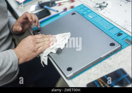 Nahaufnahme der speziellen manuellen Reinigung von Laptop, Bildschirm, Notebook, Tastatur, Tasche, Vor Staub. Reinigungszubehör: Kleiner Staubsauger, Bürste, Klo Stockfoto