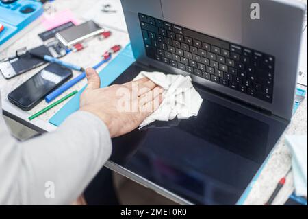 Nahaufnahme der speziellen manuellen Reinigung von Laptop, Bildschirm, Notebook, Tastatur, Tasche, Vor Staub. Reinigungszubehör: Kleiner Staubsauger, Bürste, Klo Stockfoto