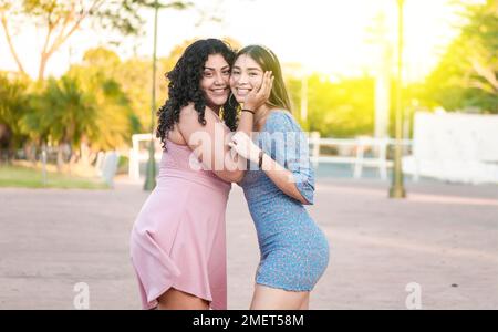 Zwei Freundinnen umarmen sich im Freien vor, Freundinnen umarmen und genießen das Leben, Frauen Freundschaftskonzept Stockfoto